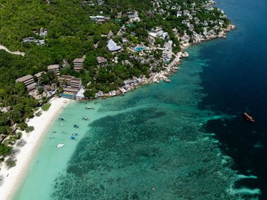 Yeşillik ve küçük teknelerle çevrili turkuaz bir körfezin panoramik görüntüsü. Köpekbalığı Körfezi. Koh Tao, Tayland.