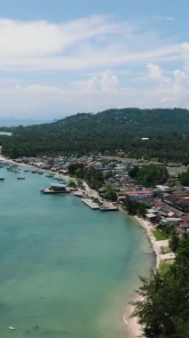 Turkuaz suları, kumlu plajları ve dağınık yerleşim alanları olan yemyeşil tepeleri olan sakin bir sahil manzarası. Ko Samui, Tayland.