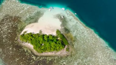 Beyaz kumlu küçük bir adada, saydam suların üzerinde tekneler. CYC Plajı. Coron, Palawan. Filipinler.