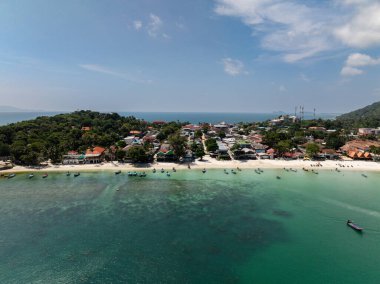 Turkuaz suların havadan görünüşü el değmemiş bir sahil şeridi boyunca tropikal yeşillikle buluşuyor. Ko Pha Ngan, Tayland.