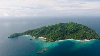 Saf plajlar ve berrak mavi sularla çevrili manzaralı bir tropikal ada. Cobrador Adası, Romblon, Filipinler.