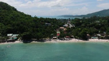Yeşil tepeler ve canlı turkuaz suyu ve kumlu kıyı şeridi olan sahil kenarındaki binalar. Crystal Bay Sahili. Ko Samui, Tayland.