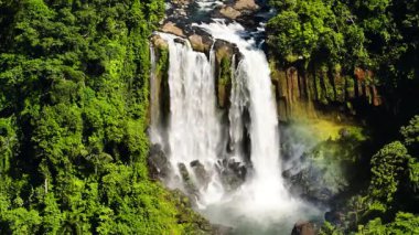 Dağ ormanlarında gökkuşağıyla kaplı iki katmanlı şelale. Limunsudan Şelalesi. Mindanao, Filipinler.