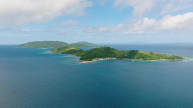 Derin mavi denizlerle çevrili yemyeşil tepeleri barındıran geniş bir tropikal ada manzarası. Romblon, Filipinler.