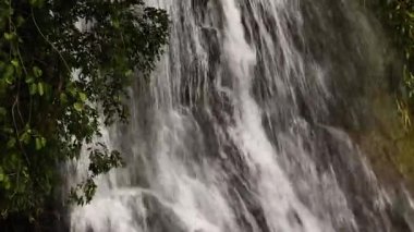 Bitkilerle çevrili kayaların üzerinden çağlayan bir şelale. Na Mueang Şelalesi. Ko Samui, Tayland.