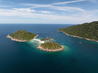 Etrafı mavi su ve teknelerle çevrili yemyeşil adaların manzarası. Nang Yuan, Koh Tao, Tayland.