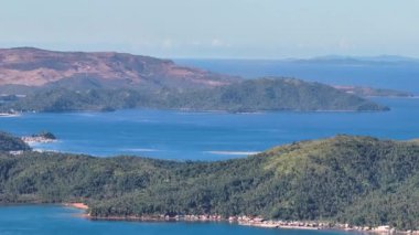 Mavi denizle çevrili tropik adalarda evleri olan kıyı şeridi. Mindanao, Filipinler. Büyütme görünümü.