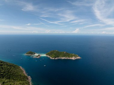 Berrak mavi gökyüzünün altında yemyeşil suları ve turkuaz suları olan tropik adalar. Koh Tao, Tayland.