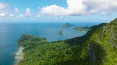 Cadlao Adası 'ndaki yemyeşil bitki örtüsü mercanlı turkuaz suyla çevrili tropikal bir manzara. El Nido, Palawan. Filipinler.