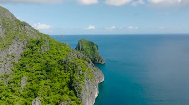 Cadlao Adası üzerinde kireçtaşı kayaları olan yüksek tepeler. El Nido, Filipinler.