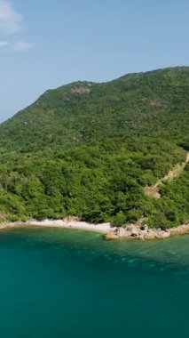 Yeşil orman tepeleriyle çevrili tropik sahil şeridi ve beyaz kumlu kumlu turkuaz deniz. Ko Pha Ngan, Tayland.