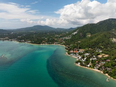 Gökyüzündeki yumuşak bulutların altında turkuaz sularda mercanları olan kumlu sahil. Koh Samui, Tayland.
