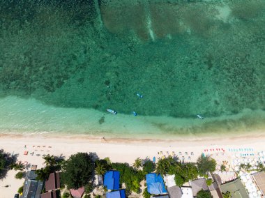 Üst manzara turkuaz su, kumlu plaj, tropik adada renkli güneşlik yatakları gösteriyor. Haad Yao. Ko Pha Ngan, Tayland.