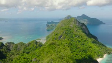 Canlı sahil kasabası yemyeşil dağların eteklerine kurulmuştur. El Nido, Palawan. Filipinler.