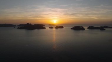 Ufuk sarı, portakal ve altın renginde parlar. El Nido 'daki adaların üzerinde gün batımı. Palawan 'da. Filipinler.