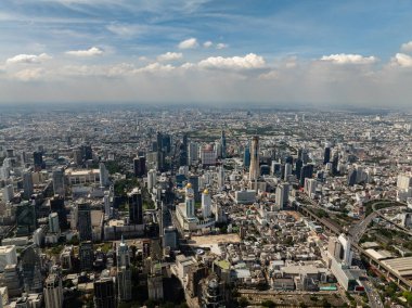 Tanınmış gökdelenler ve kentsel yayılımlar, açık gökyüzünün altındaki hareketli Bangkok şehir manzarasını oluşturur. Bangkok, Tayland.
