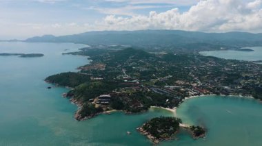 Açık mavi gökyüzü ve uzak dağ sırasına sahip turkuaz suyla çevrili adaların manzarası. Ko Samui, Tayland.