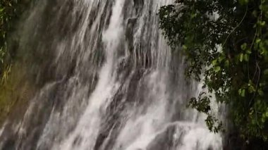 Bitkilerle çevrili kayaların üzerinden çağlayan bir şelale. Na Mueang Şelalesi. Ko Samui, Tayland.