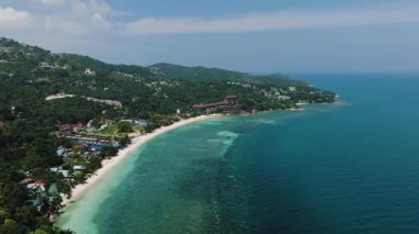 Tropikal bir adanın ormanlık kıyı şeridi boyunca turkuaz suları. Haad Yao. Ko Pha Ngan, Tayland.