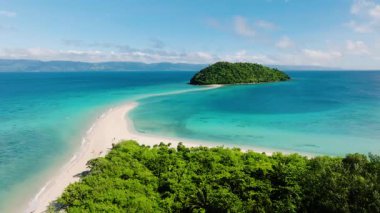 Kristal berraklığında turkuaz sularla çevrili yeşil bir adayı birbirine bağlayan el değmemiş bir kumluk. Bon Bon Plajı, Romblon, Filipinler.