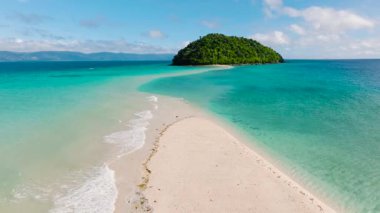 Açık gökyüzünün altındaki tropikal kum yığınının üzerindeki okyanus dalgalarının havadan görünüşü. Bon Bon Bon, Romblon, Filipinler.