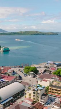 Romblon Adası 'ndaki ticari binaların ve sokakların havadan görüntüsü. Mavi denizin üzerinde feribot. - Evet. Romblon, Filipinler. Dikey görünüm.