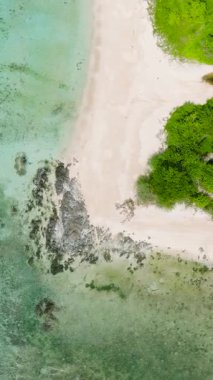 Turkuaz suyun üzerine güneş ışığı yansıması. Tropik sahildeki mercan kayalıkları. Santa Fe, Tablas, Romblon. Filipinler. Dikey görünüm.