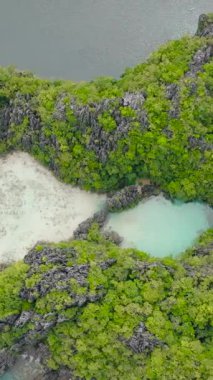 Miniloc Adası 'ndaki muhteşem kireçtaşı oluşumlarıyla çevrili tekneli lagünlerin havadan görünüşü. El Nido, Filipinler. Palawan 'da. Dikey görünüm.