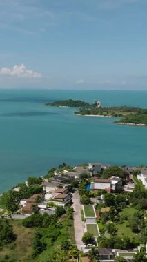 Turkuaz deniz manzarası, yemyeşil kıyı şeridi ve uzakta küçük bir ada. Bo Put. Ko Samui, Tayland.