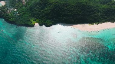 Parlak turkuaz sular, yemyeşil çevresiyle beyaz kumlu plajla buluşur. Puka Kabuğu, Boracay Adası, Filipinler.
