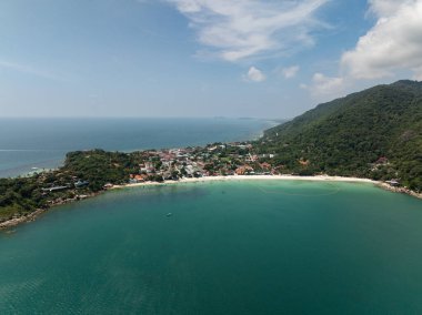 Tropik yeşil ve turkuaz sularla çevrili tropikal kıyı kasabası, parlak mavi bir gökyüzünün altında. Haad Rin. Ko Pha Ngan, Tayland.