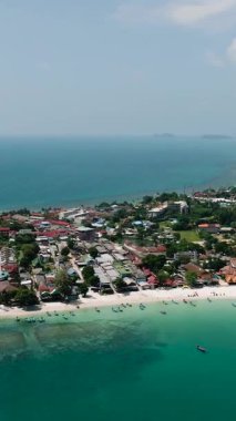 Arkasında kumlu plajlar ve yeşil tepeler olan canlı bir sahil şeridi. Haad Rin. Ko Pha Ngan, Tayland.