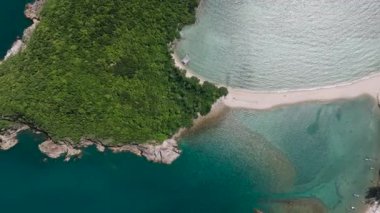 Bereketli yeşil tepeler ve kayalık kıyı şeridi ile turkuaz su arasındaki kum kayası. Ko Ma Sahili. Ko Pha Ngan, Tayland.