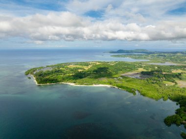 Island with beach and turquoise sea water. Blue sky and clouds. Looc, Tablas Island. Romblon, Philippines. clipart