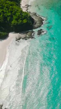 Beyaz sahil ve turkuaz okyanus dalgaları ve mercanlar. El Nido, Palawan. Filipinler. Dikey görünüm.