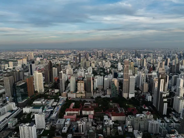 Bangkok 'un gökdelenlerle aydınlanan gökdelenleri ve solan mavi gökyüzünün altındaki yoğun kentsel manzarasıyla akşam manzarası. Bangkok, Tayland.