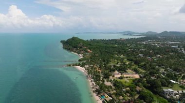 Beyaz kumlu plajlar, yeşil tepeler ve dağınık evleri ve tatil beldeleri olan turkuaz okyanus sahili. Ko Samui, Tayland.