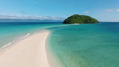 Sakin turkuaz sularla çevrili tropikal bir ada ve denize doğru uzanan bir kumluk. Bon Bon Plajı, Romblon, Filipinler.