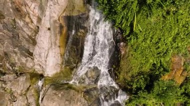 Bereketli orman arazisinden akan sarp şelale ve yoğun yeşil bitki örtüsüyle kayalık uçurumlar. Na Mueang, Ko Samui, Tayland.