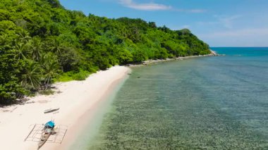 Canlı yeşillikle sakin bir kıyı manzarası. El Nido, Palawan 'daki Cagbuli Adası' nda beyaz kumlar ve berrak sular. Filipinler.