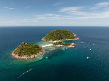 Canlı mavi sularda demirli teknelerle bağlı tropikal adanın havadan görünüşü. Nang Yuan, Koh Tao, Tayland.
