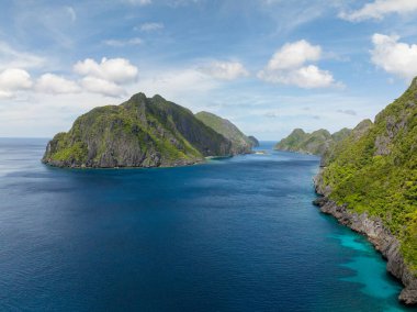 Tapiutan ve Matinloc, mavi denizli adalar. Mavi gökyüzü ve bulutlar. El Nido, Filipinler.