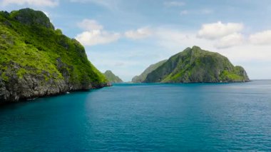 Mavi denizle çevrili tropik adaların deniz manzarası. Kayalık oluşumlar denizden görkemli bir şekilde yükselir. El Nido, Palawan. Filipinler.