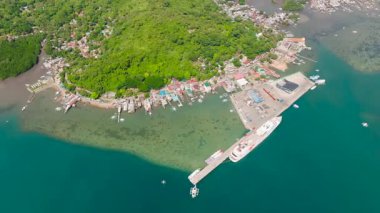 Coron Limanı 'nın kıyı şeridindeki turkuaz suları olan yolcu feribotunun üst görüntüsü. Coron, Palawan. Filipinler.