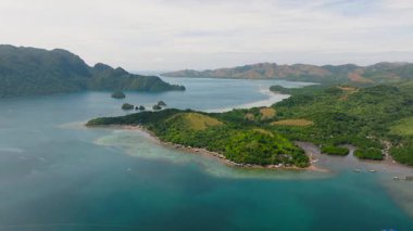 Sahile yakın evleri olan bir ada. Mavi deniz ve adacıklar Coron 'da. Palawan, Filipinler.