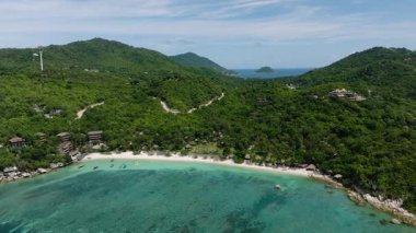 Zümrüt yeşili sular yoğun orman tepeleri ve dağınık sahil tatil beldeleri olan tropikal bir kıyı şeridiyle karşılaşır. Köpekbalığı Körfezi. Koh Tao, Tayland.