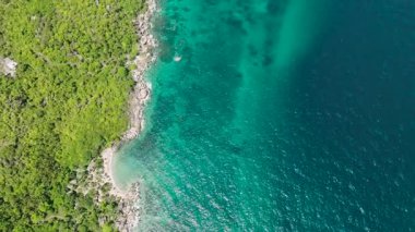 Turkuaz okyanus suları ve kayalık kıyı şeridiyle yemyeşil kıyı şeridi. Koh Tao, Tayland.