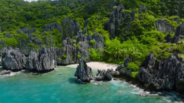 Uçurumların arasına gizlenmiş beyaz bir kumsal dünyadan huzurlu bir kaçış sunuyor. El Nido, Palawan. Filipinler.