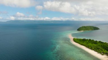 Turkuaz sular, canlı bitki örtüsü ve sakin bir ambiyansı olan verimli tropikal kıyılarla buluşuyor. Bon Bon Plajı, Romblon, Filipinler.
