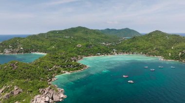 Bereketli yeşillikler ve dağınık kulübelerle çevrili durgun suları olan turkuaz körfez. Koh Tao, Tayland.